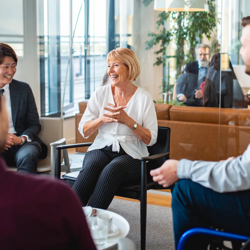 A diverse group of people in a bright office setting, engaged in a lively discussion. 