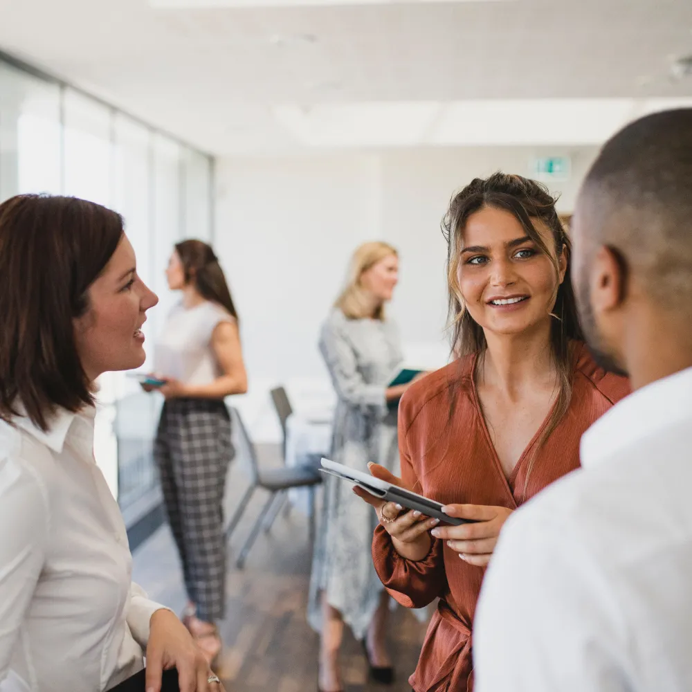 A diverse group of people in a bright office setting, engaged in a lively discussion. 