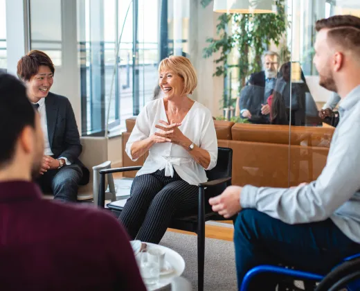 A diverse group of people in a bright office setting, engaged in a lively discussion. 