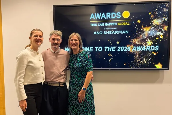 CiC Wellbeing team members at This Can Happen Awards event stood in front of the awards screen