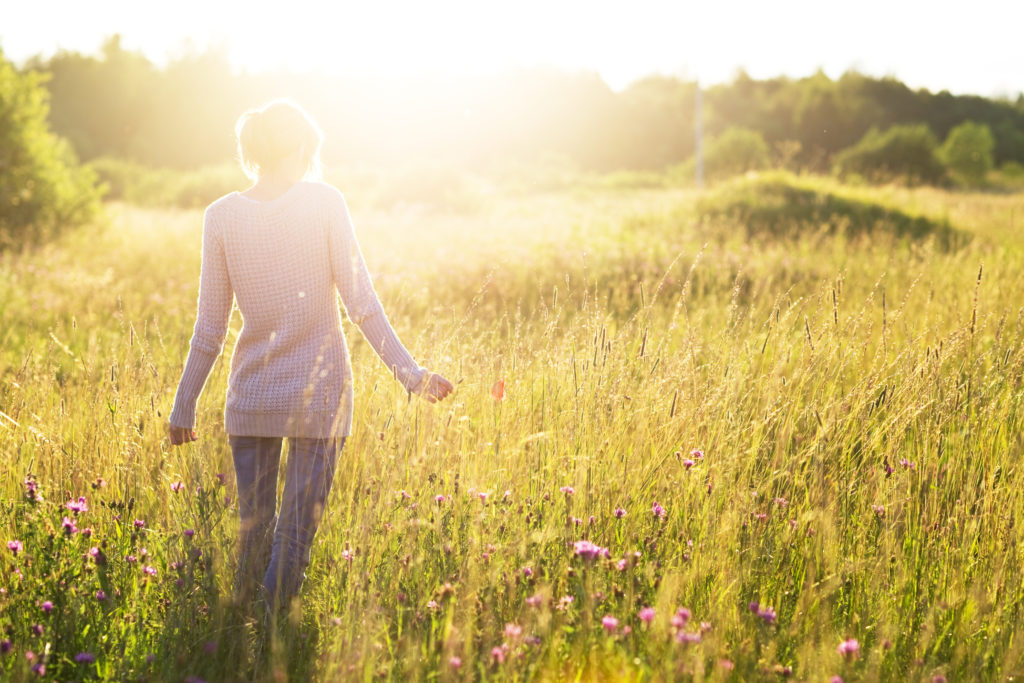 Woman Walking Through Grass | Wellbeing Programmes