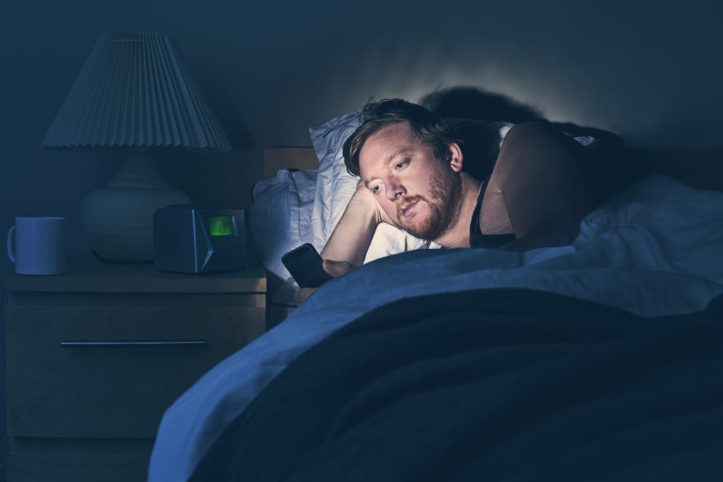 Man on phone in bed