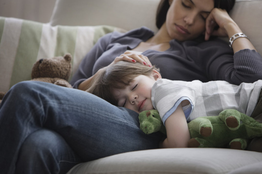 Tired mum falling asleep with young child