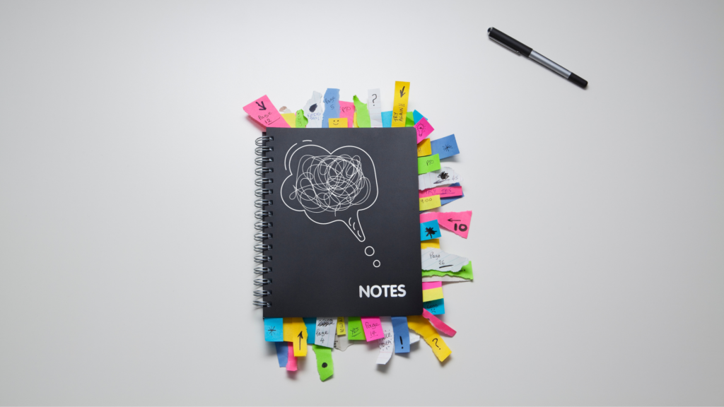 Notebook with post it notes bursting out